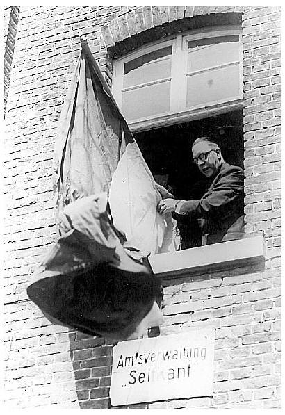 23. April 1949: Landdrost Hubert Dassen hngt um 12 Uhr mittags die niederlndische Fahne an sein Amtsgebude in Selfkant.